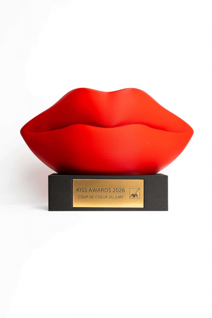 Trophée personnalisé en impression 3D filament représentant une sculpture de lèvres rouges sur socle noir avec plaque personnalisée, fabrication française.